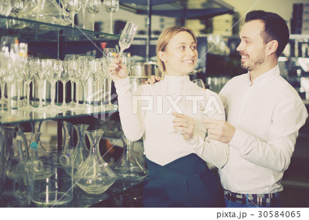 Couple choosing new wine glasses 30584065