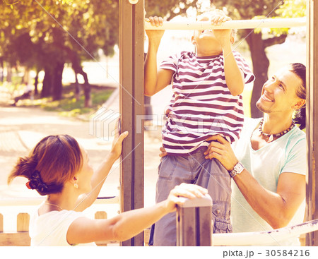 family with teenage son training on pull-up bar 30584216