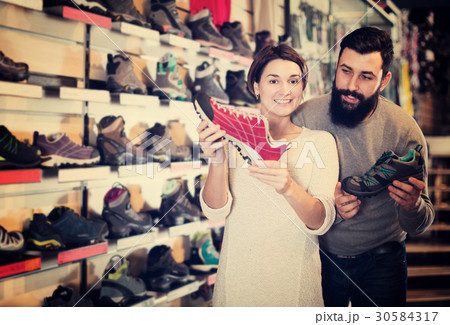 Couple deciding on new sneakers Couple deciding on new sneakers 30584317