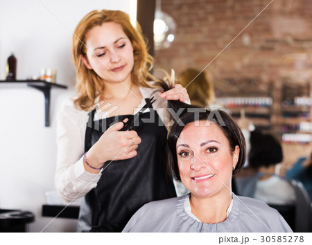 Young hairdresser working in salon 30585278
