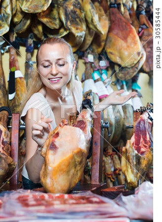 Positive female customer choosing iberian ham 30585444