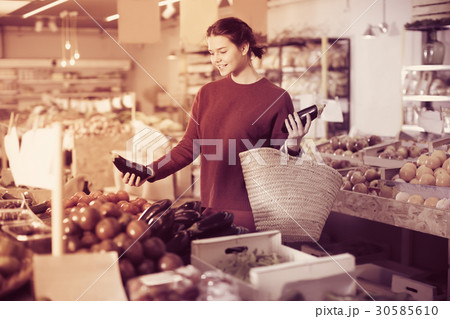Calmness girl buying aubergines at market 30585610
