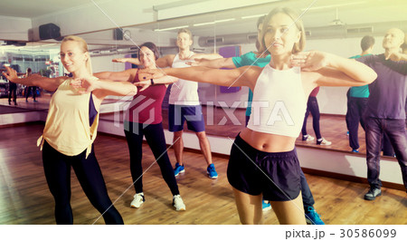 People learning zumba elements together in dancing class People learning zumba elements together in dancing class 30586099