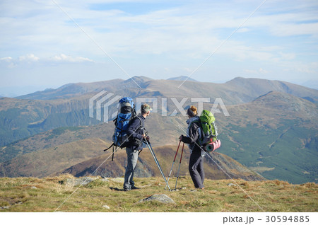 Couple hikers in the mountains with backpacks 30594885
