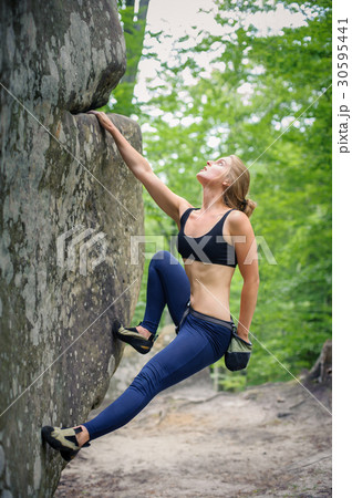 young woman climbing on large boulders outdoor young woman climbing on large boulders outdoor 30595441
