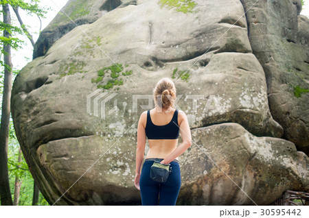 Woman with climbing equipment in front of a stone 30595442