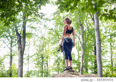 woman on the top of rock after climbing boulder woman on the top of rock after climbing boulder 30595454