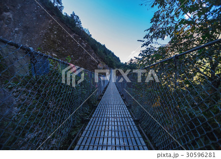 Suspension bridge in the mountains 30596281