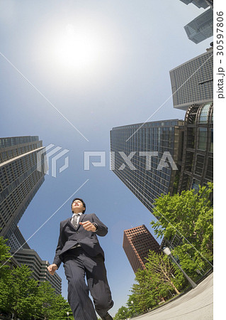 走るビジネスマン　超広角で真下から見上げる　丸の内　太陽と逆光 30597806