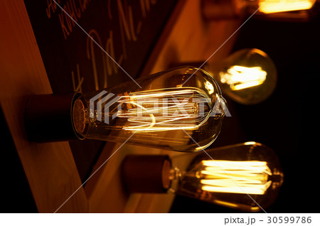 Edison light bulb hanging on a long wire. Cozy Edison light bulb hanging on a long wire. Cozy 30599786