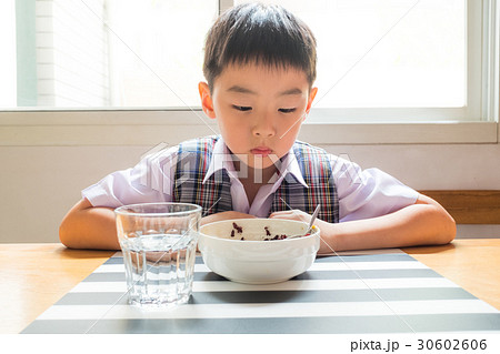 Thai boy looks unhappy during breakfast 30602606