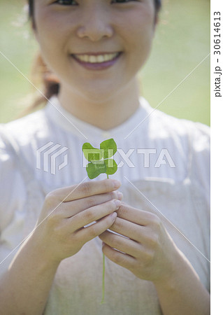 四つ葉のクローバーを持つ女性 30614613