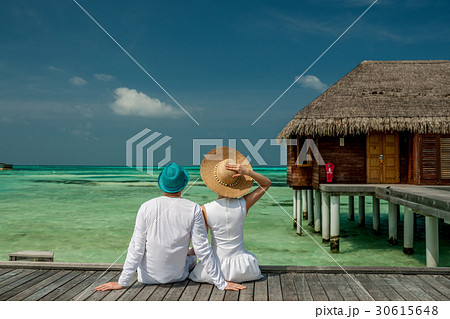 Couple on a beach jetty at Maldives Couple on a beach jetty at Maldives 30615648