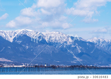 雪の比良山系と琵琶湖大橋の写真素材