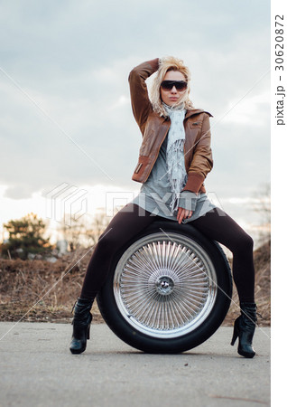 Sexy young girl sits on a large wheel 30620872