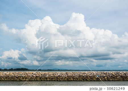 Dam rock on the sea with blue sky and clouds Dam rock on the sea with blue sky and clouds 30621249