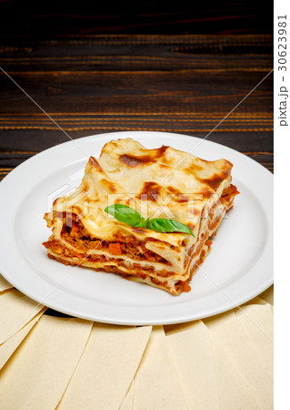 Portion of tasty lasagna on wooden backgound 30623981