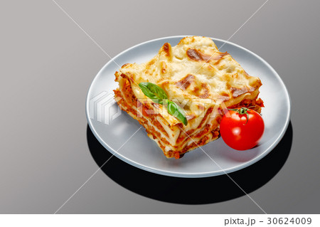 Portion of tasty lasagna on grey background Portion of tasty lasagna on grey background 30624009