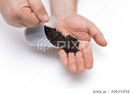 Plastic pellets spilled out of the measuring Cup  30625956