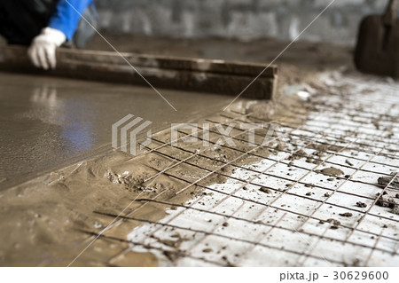 Worker making cement screed on the floor view 30629600