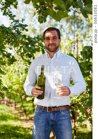 Man with a glass of white wine in the vineyard 30633081