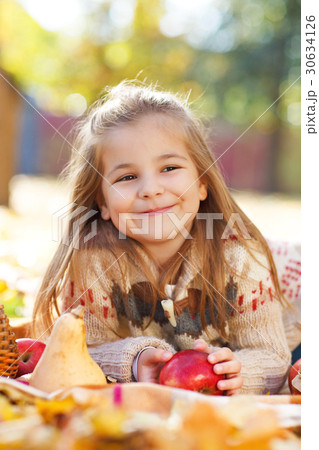 Adorable little girl with autumn leaves and apple 30634126