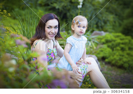 Beautiful young mother and daughter in summer park 30634158