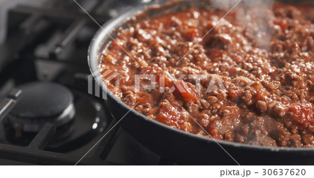 roasting minced beef with tomato paste in a pan 30637620