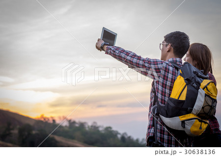 Tourists look at a map on the tablet on mountain. 30638136