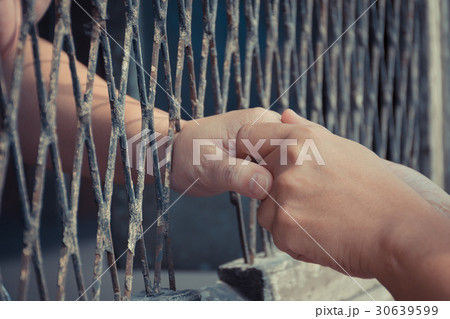 Hands of the man and woman on a steel lattice Hands of the man and woman on a steel lattice 30639599