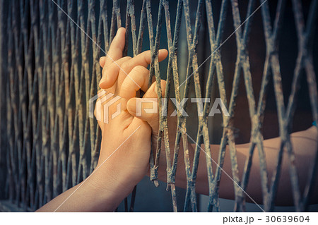 Hands of the man and woman on a steel lattice Hands of the man and woman on a steel lattice 30639604