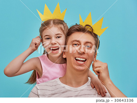 Dad and child are holding paper crown 30643336
