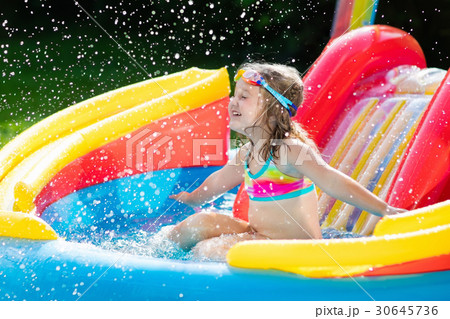 Child in garden swimming pool with slide Child in garden swimming pool with slide 30645736