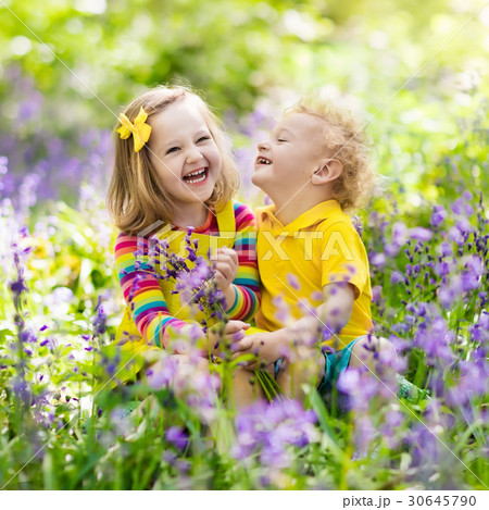 Kids in blooming garden with bluebell flowers 30645790
