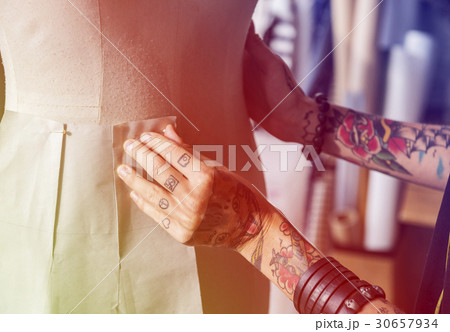 Fashion designer hands tattoo pin pattern of clothes with figure model 30657934