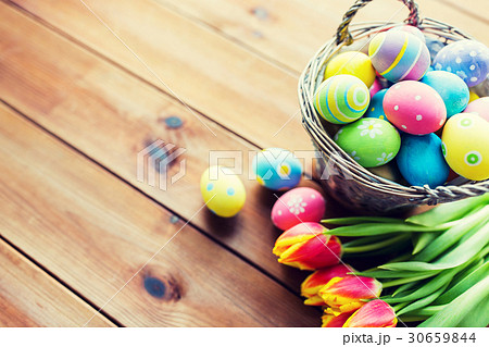 close up of easter eggs in basket and flowers 30659844
