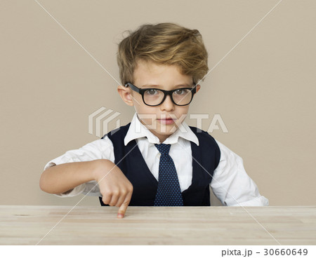 A Caucasian Boy Pointing Wooden Table Background Studio Portrait 30660649