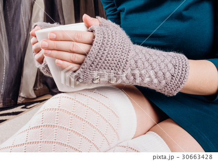 Hands in gloves hold a cup 30663428