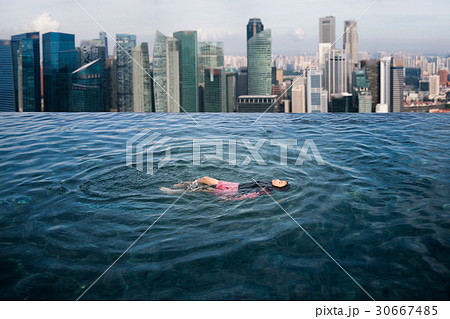 Asian girl swimimg in the roof top swimming pool  30667485
