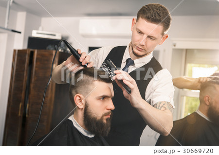 Professional barber doing a haircut Professional barber doing a haircut 30669720