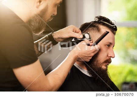 Professional barber doing a haircut 30670070