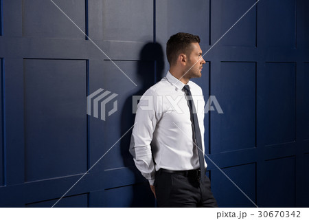 Youthful sad man standing at wall Youthful sad man standing at wall 30670342