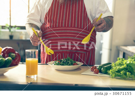 Thick guy mixing salad in kitchen Thick guy mixing salad in kitchen 30671155