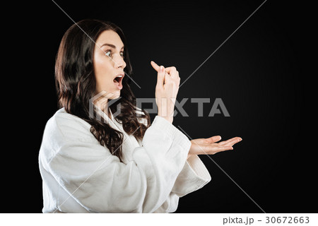 Shocked brunette looking at her forefinger Shocked brunette looking at her forefinger 30672663