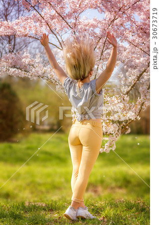 Beautiful happy young woman in a flowering spring garden 30673719