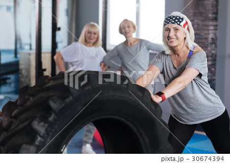 Nice strong woman standing near a huge tire 30674394