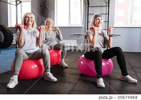 Positive elderly women holding dumbbells Positive elderly women holding dumbbells 30674968