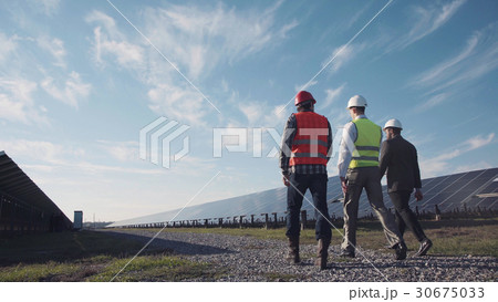 Technician walks with workman and investor 30675033