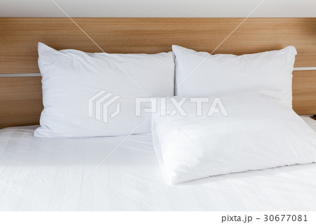 White pillows lay on wide empty bed 30677081