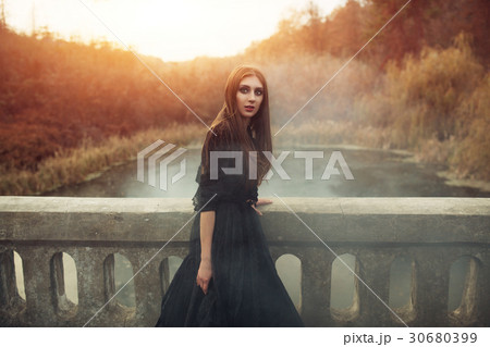 Young attractive Witch walking on the bridge Young attractive Witch walking on the bridge 30680399